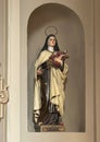 Carved wooden polychrome statue of Mary with Roses in the Church of Saint Stephen in Menaggio on Lake Como.