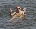 Caucasian male, husband of a Korean wife, giving the Emeka hand signal as he floats in Grand Lake, Oklahoma on July 4th, 2022.