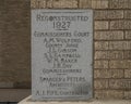 Closeup of an information plaque of engraved stone in a brick wall of the old Commissioner`s Court Building in McKinney, Texas.