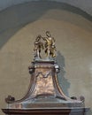 Closeup view of a sculpture of the baptism of Jesus atop the baptismal in the Church of Saint George in Varenna.