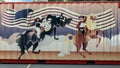 Cowgirl and cowboy on horses painted on a large trash bin at the first State Fair of Texas drive through event in 2020.
