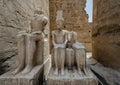 Deteriorating statue of the god Amun-Re and his wife Mut and a seated king just before the Colonnade Hall in Luxor Temple, Egypt. Royalty Free Stock Photo