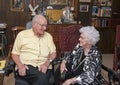 Elderly couple celebrating wife`s 86th birthday in their home as they share an affectionate look. Royalty Free Stock Photo