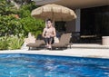 Eleven year-old boy doing a cannonball into a swimming pool