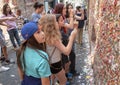 Family on vacation ready to stick gum on The Market Theater Gum Wall, Pike Place Market, Seattle, Washington