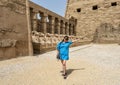 Female Korean tourist and row of ram-headed sphinxes in front of a row of columns in the first courtyard of the Temple of Amun. Royalty Free Stock Photo