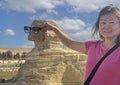 Female Korean tourist and The Great Sphinx of Giza, on the Giza Plateau in Giza, Egypt.