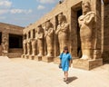 Korean tourist and Osiride sculptures of King Ramesses III in the courtyard of his temple in the Karnak temple complex.