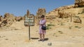 Tourist with painted steel sign for Gebel Al Mawta, the `Mountain of the Dead`, in Siwa Oasis, Egypt. Royalty Free Stock Photo