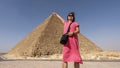 Female Korean tourist and The Great Pyramid of Giza, tomb of Fourth Dynasty pharaoh Khufu, in the Giza Pyramids complex in Egypt.