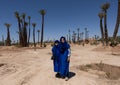 Female tourist and her husband dressed in Arabic garb, ready for a camel ride in Marrakesh.