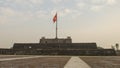 The flag tower of Hue Citadel with the flag of Vietnam flying in the wind.