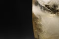 A glass of ginger ale in a black background