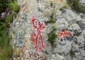 Graffiti covered stone wall along trail from La Turbie to Tete de Chien, southeastern France.