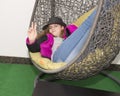 Hip eleven year old girl relaxing in an egg chair