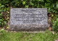 Inscribed dedication stone for a bronze sculpture featuring Benjamin Franklin on a bench in Turtle Creek Park in Dallas, Texas.