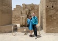 Tourist couple before the statue of the god Amun-Re and his wife Mut just before the Colonnade Hall in Luxor Temple, Egypt. Royalty Free Stock Photo