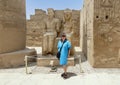 Korean female tourist before the statue of the god Amun-Re and his wife Mut just before the Colonnade Hall in Luxor Temple, Egypt. Royalty Free Stock Photo