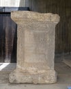 Limestone statue base with Latin dedication on display at the Archaeological Site of Volubilis in Morocco.