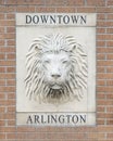 Lion face stone relief imbedded in a brick column at an entrance to downtown Arlington, Texas.