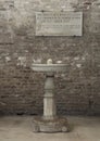 Marble water basin and plaque inside the Basilica of Sant Appolinare Nuovo in Ravena, Italy. Royalty Free Stock Photo