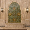 Moroccan mosaic tile surrounded by marble and flanked by decorative lights inside the Hassan II mosque in Casablanca, Morocco. Royalty Free Stock Photo