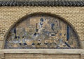 Mosaic tile painting of master artisan on the brick outside wall of Art Naji in Fez, Morocco.