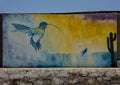 Mural featuring the Hummingbird and Whale by artist Luis Angel Morales along a street in Todos Santos.