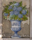 Tile mosaic with flowers in a vase on the outside of an old building in Lisbon, Portugal.