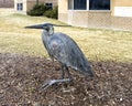 Bronze sculpture of a heron with McGloin Hall in the background on the campus of Creighton University in Omaha, Nebraska.