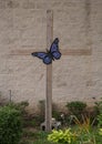 Painted purple metal butterfly attached to the cross at the United Methodist Church of Saint John the Apostle in Arlington, Texas. Royalty Free Stock Photo