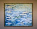 Painting featuring water lilies with red flowers floating in blue water on display in a resort on the Big Island, Hawaii.