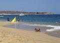 People and a dog enjoying Medano Beach on the calm waters of the Sea of Cortez in Cabo San Lucas.
