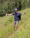 Physically-fit middle-aged Caucasian man walking a trail through a meadow atop a mountain in Beaver Creek, Colorado. Royalty Free Stock Photo