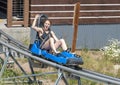 Physically fit middle-aged Caucasian woman enjoying a roller coaster like sled ride in Vail, Colorado. Royalty Free Stock Photo