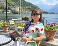 Female Korean tourist in the outdoor seating of a gelateria in Gravedona on Lake Como. Royalty Free Stock Photo