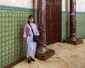 Korean tourist with mosaic tile and marble pillars inside the Hassan II Mosque Museum in Casablanca, Morocco.