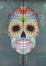 Day of the Dead mask painted on the outside of a glass door in Dallas, Texas.