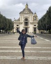 Smiling female Korean tourist in front of the Basilica of Saint Mary of the Angels just outside Assisi, Italy.