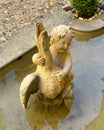 Statue of a cherub with a large waterfowl in a small fountain at the entrance to Villa Cipressi in Varenna on Lake Como.