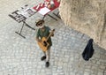 A smiling street vendor playing guitar in Matera, Italy.