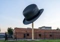 Ten foot tall and wide, 2-ton bowler hat sculpture by artist Keith Turman standing on an empty lot on Griffin Street in Dallas