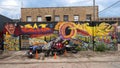 Motorcycles parked in front of a surrealistic mural by EC Crew in Deep Ellum in East Dallas, Texas. Royalty Free Stock Photo