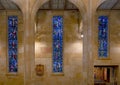 Three stained glass windows and the 5th of the Fourteen Stations of the Cross inside Christ the King Catholic Church in Dallas