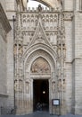 Tourists with COVID masks exiting the Puerta de Palos on the East facade of the Seville Cathedral in Spain.