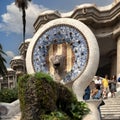 Mosaic dog fountain and white tiled staircase at entrance to Park Guell in Barcelona, Spain..