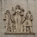 Weathered old stone relief featuring Saint Apollonia flanked by a modern dentist and an early dentist in downtown Tulsa, Oklahoma. Royalty Free Stock Photo