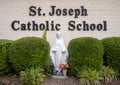 White statue of the Virgin Mary on a blue tile base at Saint Joseph Catholic School in Arlington, Texas.