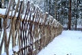 Wicker fence covered with snow Royalty Free Stock Photo