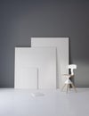 Pictures and chair in gray studio with atmospheric lighting